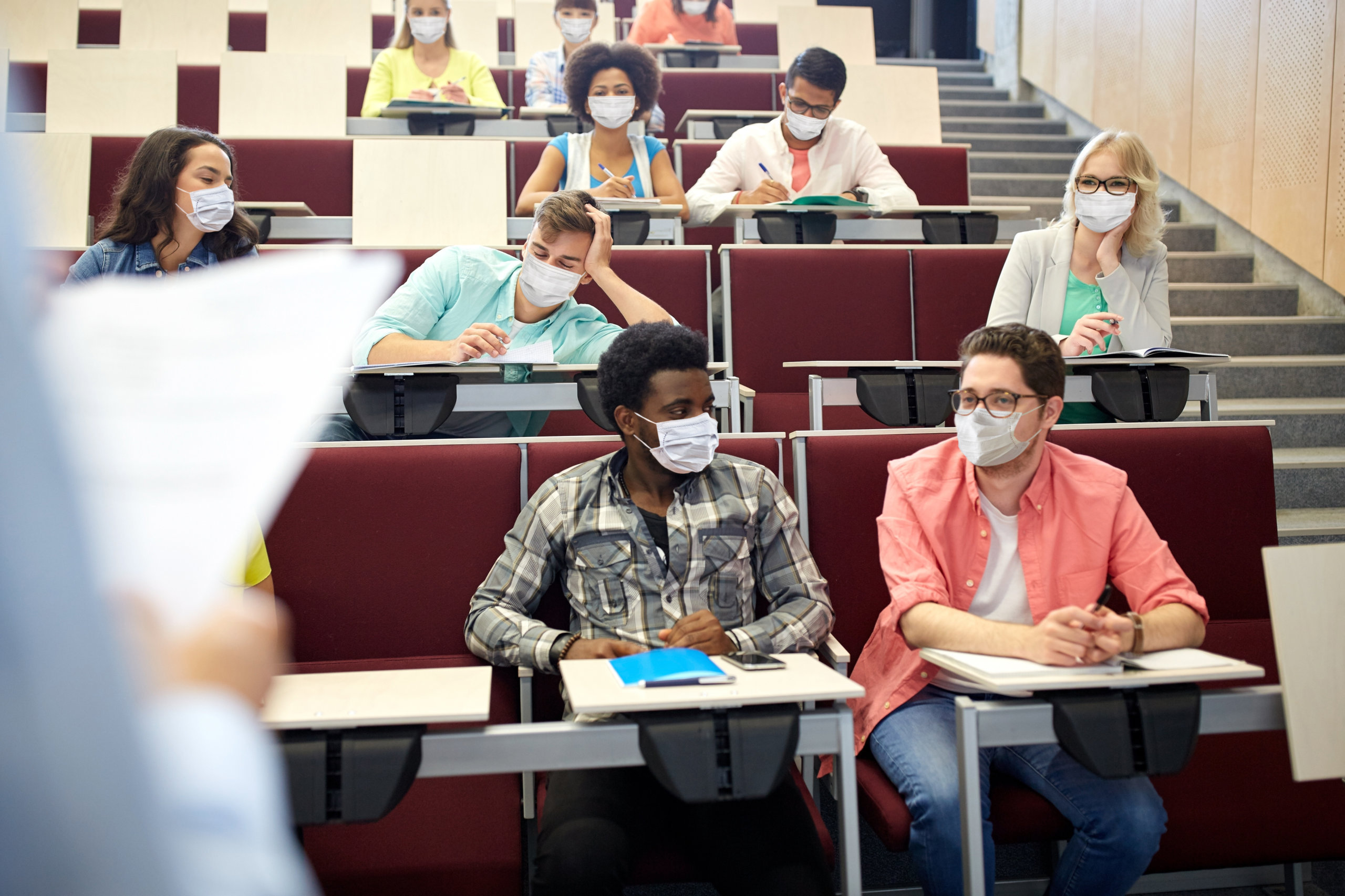 group of students in masks at lecture hall